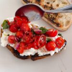 Laura Vitale Instagram - Just wanted to share my latest fixation with you that’s been on repeat because it’s so good!!!!! I’m no tiny eater (as in, I’m no almond mom I’m a chicken cutlet mom 😂😂) and I’ve been loving this cottage cheese bruschetta situation and can only imagine how amazing it will be with garden fresh summer tomatoes! Make a little tomato salad, toast some bread (linking tostapane in stories!) top with cottage cheese and marinated tomato situation and go to town!