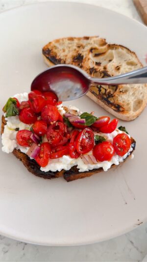 Laura Vitale Instagram - Just wanted to share my latest fixation with you that’s been on repeat because it’s so good!!!!! I’m no tiny eater (as in, I’m no almond mom I’m a chicken cutlet mom 😂😂) and I’ve been loving this cottage cheese bruschetta situation and can only imagine how amazing it will be with garden fresh summer tomatoes! Make a little tomato salad, toast some bread (linking tostapane in stories!) top with cottage cheese and marinated tomato situation and go to town!