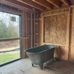 Lauren Liess Instagram – The CORRECT 200-something-year-old tub has arrived at the Meadow!! 🛁And it is green!! (Phew!!) I’ve been going back and forth internally on its positioning… I have always planned for it to span left-to-right in front of the back window (1st video/ 2nd slide) but can’t forget how much I loved baths in our old tub which faced straight out out a (side) window so I’ve been wrestling with facing it towards the back window (3rd   4th slides). The glass door to the left side will lead to a walled-in garden with outdoor showers in it and the back window (not in yet) looks out to the back yard. I love the silhouette of the tub when it’s sideways and space-wise it fits the room perfectly but I can’t unsee the thought of those facing those views straight on. Here it is both ways and I’m 99.9% on team facing the views now. It somehow feels more authentic to me, having the tub face the way we will naturally want to look but I’m a little sad to see less of the tub straight on and I don’t love having my back to the room. Something I’ve written a bit about in the past is that there are some spaces where the “enjoyment” arrangement (the one you will be using and enjoying while in the space) isn’t as pretty upon entry or to look at… in these cases I think about pros and cons (enjoyment in the room usually wins unless it’s just way too awkward-feeling.) I’ll be posting a video update of our final decision once it’s made… what would you do?? Are you on Team sideways or Team Views?? 🫧 {Also, if you haven’t seen it, our first Meadow House episode is up on y o  u. T ube!