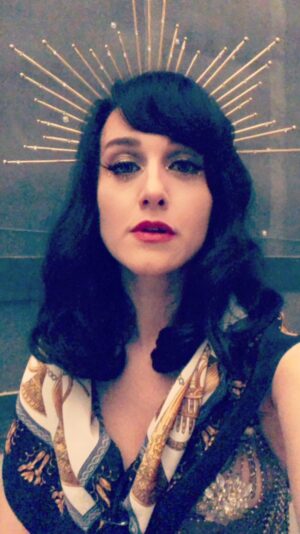 Lena Hall Instagram - From fitting to film! This #missaudrey costume was one for the books! @cynthiasummers put this gorgeous look together making me feel like an Erté. That’s a chain mail dress over a satin corset with jeweled pasties. Topped with a velvet and satin robe and a crown! Make up @rosalina_mup added some diamontes! EPIC! What’s your favorite part of this costume! Comment below and don’t be cheeky! 😘 @snowpiercertv @amcplus @amc_tv @tomorrowstudiostv