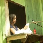 Letícia Tomazella Instagram - O ano era 2015 e fui pro Acre pela primeira vez (e voltei lá dois anos depois). Desde então, tenho uma saudade enorme. @vanessabalduyna, que sempre me recebeu em sua casa e me ensinou o que era Jirau (lugar onde eu lavei roupa, na última foto), dizia que eu tinha a alma acreana. Mas o que vim contar foi o diálogo que tive com essas duas indígenas lindas, com quem passei dias brincando e nadando no Rio Muru, na aldeia Huni-Kuin, em Tarauacá. A mais velha era mais tímida, a mais nova muito espevitada e tinha vontade de conhecer outros lugares. Elas nunca tinham saído dali. Começou um diálogo que nunca mais esqueci, puxado pela caçula: - Letícia, vc mora onde? - Em São Paulo. Mas não nasci lá, nasci e cresci numa cidade muito pequenina. Mas hoje moro na capital. - E mora muita gente lá? - Onde? Em São Paulo? - É. - Mora... Mora muuuita gente lá. - E você veio como pra cá? - De avião até Rio Branco. Depois de carro e um trecho de barco até aqui. Nunca tinha andado assim de barco. - É legal andar de carro? - Vc nunca andou? - Não. É legal? - Sei lá. Acho normal. Nada demais. Você anda de quê? - De barco pra todo lugar. - E é legal andar de barco pra todo lugar? - Sei lá. Normal. Nada demais. Rimos. Prossigo: - Pra mim foi bem especial andar de barco pela primeira vez pra vir pra cá. Cê vê que a gente se acostuma com as coisas e acaba achando tudo meio sem graça, mas no fundo tem muita graça. Ela riu e concordou. E volta a me fazer perguntas: - Rio Branco é bonito? - Eu achei lindo. Vc nunca foi? - Não. Mas eu devo ir com meu pai de carro pra Rio Branco, ele disse que vai me levar um dia. Ela sai nadando e atravessa o rio mil vezes. Eu peço pra ela ter cuidado, e eu saio nadando toda medrosa. Que tolice a minha de achar que ela tem que ter cuidado porque é criança. Ela nasceu fazendo aquela travessia. A infância inteira é solta ali, nadando, andando. A floresta é casa delas. E a casa da gente aconchega, não assusta. Fui embora do Acre de alma lavada. Vendo que a coisa mais rica do mundo é a simplicidade que só a natureza pode nos ensinar. O que eu mais desejo é que em 2024 a floresta seja muito protegida. Mesmo. Viva a Amazônia! 🌳🍀 #tbt