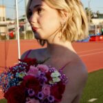 Lily Brooks O'Briant Instagram - When your sister comes in clutch & helps sneak you onto the football field at her HS for a photo shoot 🤫 • Thank you so much @prompartyshop for letting me use these beautiful dresses for the shoot! & a huge thank you to @ja.photographic & @lo.photographic for these incredible photos! 💐✨ • • #singer #newsong #newartist #newmusic #seventeen #17 #singersongwriter #music #musician