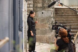 Lulu Wang Instagram - #Director Lulu Wang (@thumbelulu) and #DOP Anna Franquesa-Solano AEC (@annafranquesasolano) take us #behindthescenes of #Expats, shot with #Panaspeed lenses and serviced by #Panavision Woodland Hills.

Anna begins: 
“We wanted to capture a sense of restraint, since the three protagonists are constantly making an effort to not let go or surrender to their emotions, knowing that if they do, they will get lost. It is this attempt to keep control over their lives that influenced much of the visual look—subdued and constrained.”

Lulu continues: 
“Anna and I watched films together and also referenced photographers Michael Wolf and Christopher Anderson. We discussed how we’d visually represent this wound, this unseen thing. We also talked a lot about the contrast of the different worlds and spending a lot of time on the ground in Hong Kong gave us a lot of inspiration.”

Anna continues: 
“The reason why I went to Panavision for this project is because they have some of the best glass in the world and they were open to work with me to develop and find the look. The Panaspeeds gave us the control over the image that felt appropriate for the look. After performing some tests, Dan Sasaki modified them to be less sharp, softening the bokeh, controlling the flare to a minimum, and having very subtle glare around highlights, so we didn’t need any filtration during the shoot. 
We kept the look very clean, with no aberrations or flares to soften the reality that these women have to go through.”

Lulu concludes:
“The scale of EXPATS was far greater than anything I’ve done before, and it gave us a ton of runway to play with different visual languages and thematic ideas. It was important for us to be expansive without losing the intimacy or specificity for each character and their particular world. 

I became a director because I wanted to tell stories that transport you to another world and into another perspective. What keeps me inspired these days is collaboration. I love how collaboration expands my worldview and it helps me to continue learning and growing.”