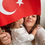 Müjgân Ferhan Şensoy Instagram - “Ey yükselen yeni nesil, gelecek sizsiniz. Cumhuriyeti biz kurduk, onu yükseltecek ve yaşatacak sizsiniz.” Mustafa Kemal Atatürk Bugün Cumhuriyet’in 100. yaşını kutlarken, bu sözler vardı aklımda. Görevimiz, bir gün burda olmadığımızda da aynı bilinçle Ata’mızın mirası olan; laik, demokratik ve çağdaş Türkiye Cumhuriyeti’ne sahip çıkacak nesiller yetiştirmek. Bizim 100. yıl anılarımız böyle. Bir gün Pera da geriye dönüp baksın diye burda dursun. Bir de 20 yıl önce yola çıkmış harika bir mektup teslim aldık bu bayram. O gün yirmi yaşında bir genç olan Canan Hanım’ın bugün hayatta olmayan babama yazdığı mektup bizi çok duygulandırdı. Yaşasın Cumhuriyet! 🇹🇷🎈❤️