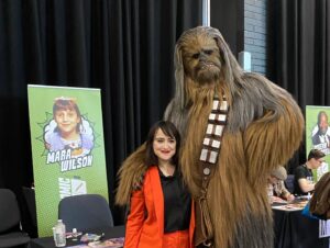 Mara Wilson Instagram - I had SUCH a great time at @comicconlpool! Thank you, lovely Liverpudlians, for making me feel so amazingly welcomed.

And thank you to all the mums and dads who helped their daughters dress as Matilda! As you can see in this photo from @liverpoolecho, I was in tears over it. TOO CUTE!

Also, just for fun, here’s me and Chewbacca.

#liverpool #comicconliverpool #comicconliverpool2022 #monopolyevents