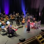 Margherita Vicario Instagram - É successa una cosa strana: il film Gloria! é uscito dallo schermo e s’é materializzato nella vita vera: abbiamo fatto un concerto in Chiesa a Molfetta, metà pubblico un po’ basito, l’altra metà trascinato dal rito. É stato divertente. Alla fine hanno rimbombato le mura ed erano tutti contenti. Ho pensato diverse volte durante queste prime tre date del tour, in questo eccesso di vitalità, che se fossi nata 4/5 secoli fa, m’avrebbero tranquillamente bruciato su un bel rogo! Chissà, magari non avrei avuto il coraggio di essere una vera strega…con la mia piantina nel vaso, lo sguardo di sguincio etcetc…Comunque ho suonato con la meravigliosa @orchestra_magna_grecia che mi ha fatto piangere 8/9 volte, come quando ho sentito per la prima volta Castagne con gli arrangiamenti di @giovannipallotti e del Maestro @patti_carmelo ❤️ Grazie a @vivoconcerti @metatronmgmt onnipresente @camilla_monge, ai miei musicisti e la mia squadra tecnica che ogni volta che li vedo sono felice di stare tra le loro mani. Ah! un grazie speciale alla ragazza che mi ha portato il CIOÉ. Dopo la Messa, ci stava. Le 3500 lire spese meglio della vita. Ci vediamo in tour❤️ PROSSIMA DATA 30 MAGGIO @ateneika_official CAGLIARI CON. BAND!!!