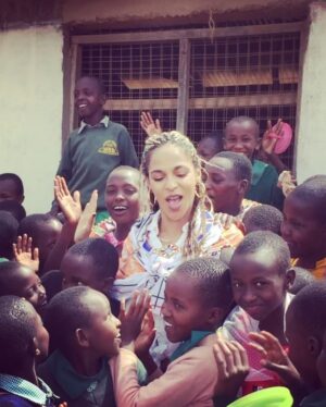 Megalyn Echikunwoke Instagram - Day 2 in Kaijado at Sanare/Arroi primary school. Ahhh! Well besides the fact that when I asked to sit down and take  a picture with them I broke their bench, crashed to the ground and they all pointed and laughed for which I could hardly blame them, they also have a glorious choir that performed for us AND are educated about the impotance of effective hygiene practices to prevent communicable diseases like trachoma through @amrefhealthafrica “WASH” program which is part of the community water project from my stories. These little plastic jugs “tippy taps” tied to trees or hand and face washing stations fueled by the community water pump ensure that these kids dont get sick and can stay in school. In the first video they are welcoming me “Karibu!” (even though I broke their bench)  telling you who they are and saying “hi to USA!”