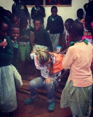 Megalyn Echikunwoke Instagram - Day 2 in Kaijado at Sanare/Arroi primary school. Ahhh! Well besides the fact that when I asked to sit down and take  a picture with them I broke their bench, crashed to the ground and they all pointed and laughed for which I could hardly blame them, they also have a glorious choir that performed for us AND are educated about the impotance of effective hygiene practices to prevent communicable diseases like trachoma through @amrefhealthafrica “WASH” program which is part of the community water project from my stories. These little plastic jugs “tippy taps” tied to trees or hand and face washing stations fueled by the community water pump ensure that these kids dont get sick and can stay in school. In the first video they are welcoming me “Karibu!” (even though I broke their bench)  telling you who they are and saying “hi to USA!”