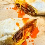 Nyesha Arrington Instagram - Simple things can be great... it's all about execution and sometimes an uncomplicated breakfast burrito is all you need 🌯 Thiccc bacon, potato rosti, egg cooked open faced-omelette style, cheddar cheese, whole green onion confit in the bacon fat while bacon was roasting in the oven and Crystal hot sauce 🌶️ Notes: I think cooking the hashbrowns aswell as the eggs in a circle allows you to get a perfect bite every time ... when you roll the burrito, it makes a spiral of ingredients 🌀- not huge and over filled, where one bite could be all egg the next all beans or what ever other ingredients are in the burrito.. ya know what I mean? On the side: Crushed avocado and a whole charred Serrano chile YES #fridayfoodfeels #breakfastburrito #lifestyle