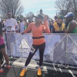Phoebe Robinson Instagram - I CAN. FUCKING. DO. ANYTHING. I started running last March as a new hobby. Fell in love with it. Did some races. And last September, (RED) asked me to run this race for them. And I did it! Wow. Surprising yourself is the coolest thing! Cannot wait to do another marathon! Running the @bostonmarathon with a chest cold is a specific kind of masochistic hell. 10 out of 10 do not recommend. Haha. But for real, the race was a surreal, incredible, once in a lifetime experience. No matter how much you prep, train, when it’s race day, you just have to meet the moment & see what you’re really made of. I saw ppl vomiting, limping, struggling; my parents lost count of how many people they saw pass out at or near the finish line. The Boston Marathon is a beast like no other and sick or not, I refused to give up. 1) Post race right after I go my medal, my dad took this photo. I was so happy, tired, and proud of myself. Baby is a marathoner! 2) On Saturday, @bankofamerica invited me and the rest of Team (RED) to a Red Sox game and I got to represent (RED) on the field during special recognition before the game started. Jumpsuit: @wearewildfang 3) Team @red - @dan_churchill, @jeffreymce, @bellezel & I - got to pose with the World Champion trophy. Neat! 4) My parents showed up looking fly AF in their matching Boston Marathon jackets that I got them. 🥰🥰 5) (RED) gang pre-race. 6) Me right before getting my marathon cherry popped. 7) Saw so many great signs thruout the race. This made me stop and laugh so hard. 8) Heartbreak Hill was no joke. Truly was hard. About 13 miles into the marathon, it felt like someone was pressing down/sitting on my chest, but I remained calm and stuck to my plan: running up HH, which was between miles 20 and 21 and lasted 1/2 mile, without stopping. And I did it! 9) This was towards the end. I was fighting for my life for the last 4 miles. I told myself to keep moving. Never stop. And remember my why: I’m doing this for (RED). It’s bigger than me. But also: this IS for me. To test myself mentally and physically. 10) My dad took the photo. He tidied up all the tables behind me because they were messy with food. #DadsOfInstagram #BostonMarathon