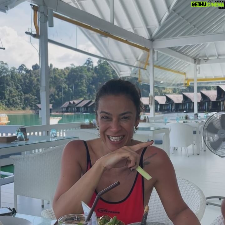 Rita Ferro Rodrigues Instagram - Day 7🤍 Atirat danphattharaworawar mais conhecido por BB é o proprietário deste paraíso . Um residente da vila local, nasceu numa família pobre mas conseguiu licenciar - se em engenharia em Bangkok onde começou a vida profissional , tendo mais tarde a oportunidade de trabalhar no estrangeiro . Sentiu sempre , porém, o dever moral de voltar para a terra onde tinha nascido e de ajudar o seu povo a ter uma vida melhor. Resolveu dedicar - se ao turismo : no @resort500rai só emprega residentes locais e … e tudo o que se consome é da região. Dizem -me que é uma figura singular, gostava imenso de o ter conhecido mas não estava cá por estes dias. Mergulhámos no lago morno e límpido, andámos de caiaque e fizemos paddle, fomos em Safari pelos margens à procura da bicharada que vive livre no seu habitat, não vimos elefantes mas um bambi olhou -nos longamente nos olhos, curioso e sem medo, antes de desaparecer pela folhagem da floresta. Preocupada com a desilusão dos pintainhos por não verem elefantes devo ter baixado o sobrolho por instantes , até ouvir o Duda dizer : “ eu não preciso de os ver para estar feliz. Sei que estão por aí naquelas árvores e saber isso chega -me” É isso filho. Às vezes não precisamos de ver, apenas de sentir. Sei que uma das preocupações do Atirat ( voltando ao dono do @resort500rai ) é ensinar inglês ao staff, pois a maioria não sabe quase nem uma palavra. Por mim não era preciso . Comunicámos por gestos e sorrisos. - e eu que estou cansada de palavras vazias - apreciei esta poupança no verbo e consequente investimento nos gestos e atitudes. Mas o melhor momento do dia foi com a minha filha Leonor, no barco, quando deitadas ao pôr do sol , demos as mãos em silêncio . ‘Cause I, I I don’t know how to feel But I wanna try I don’t know how to feel But someday, I might Billie Eilish Daqui a poucas horas abandonamos - a muito custo - este lugar encantado. Disse -lhes para guardarem tudo na retina do coração , que é onde se vê sempre melhor. Até amanhã 🫶🏽 num novo destino tailandês. O penúltimo desta aventura da mãe e dos seus pintainhos. Que para mim serão sempre pequeninos. Sempre. 🐣🐣🐣 #bestravel #bestravelviagens