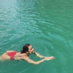 Rita Ferro Rodrigues Instagram - Day 7🤍 Atirat danphattharaworawar mais conhecido por BB é o proprietário deste paraíso . Um residente da vila local, nasceu numa família pobre mas conseguiu licenciar - se em engenharia em Bangkok onde começou a vida profissional , tendo mais tarde a oportunidade de trabalhar no estrangeiro . Sentiu sempre , porém, o dever moral de voltar para a terra onde tinha nascido e de ajudar o seu povo a ter uma vida melhor. Resolveu dedicar - se ao turismo : no @resort500rai só emprega residentes locais e … e tudo o que se consome é da região. Dizem -me que é uma figura singular, gostava imenso de o ter conhecido mas não estava cá por estes dias. Mergulhámos no lago morno e límpido, andámos de caiaque e fizemos paddle, fomos em Safari pelos margens à procura da bicharada que vive livre no seu habitat, não vimos elefantes mas um bambi olhou -nos longamente nos olhos, curioso e sem medo, antes de desaparecer pela folhagem da floresta. Preocupada com a desilusão dos pintainhos por não verem elefantes devo ter baixado o sobrolho por instantes , até ouvir o Duda dizer : “ eu não preciso de os ver para estar feliz. Sei que estão por aí naquelas árvores e saber isso chega -me” É isso filho. Às vezes não precisamos de ver, apenas de sentir. Sei que uma das preocupações do Atirat ( voltando ao dono do @resort500rai ) é ensinar inglês ao staff, pois a maioria não sabe quase nem uma palavra. Por mim não era preciso . Comunicámos por gestos e sorrisos. - e eu que estou cansada de palavras vazias - apreciei esta poupança no verbo e consequente investimento nos gestos e atitudes. Mas o melhor momento do dia foi com a minha filha Leonor, no barco, quando deitadas ao pôr do sol , demos as mãos em silêncio . ‘Cause I, I I don’t know how to feel But I wanna try I don’t know how to feel But someday, I might Billie Eilish Daqui a poucas horas abandonamos - a muito custo - este lugar encantado. Disse -lhes para guardarem tudo na retina do coração , que é onde se vê sempre melhor. Até amanhã 🫶🏽 num novo destino tailandês. O penúltimo desta aventura da mãe e dos seus pintainhos. Que para mim serão sempre pequeninos. Sempre. 🐣🐣🐣 #bestravel #bestravelviagens