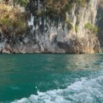Rita Ferro Rodrigues Instagram - Dia 6 🤍 Como começar ? Antes de chegarmos ao lugar mais bonito que os meus olhos alguma vez vislumbraram fizemos uma viagem de duas horas de barco - porque este lugar situa-se no Parque Nacional Khao Sok , província de Surat Thani (Tailândia) e inclui os 165 km² do Lago Cheow Lan contido pela represa Ratchaprapha. Deve ser aqui que habitam todas as divindades da natureza - só pode ser aqui o seu refúgio - pois não é possível tanta beleza existir sem um qualquer toque divino. Aguardámos pelo barco com uma futebolada com crianças locais, fizemos a viagem com Sol, por entre várias tonalidades de água quente e doce que abraça escarpas magníficas e verdejantes, todas as cores da natureza em intensidade máxima, um espectáculo de poder do natural em bruto, uma parte do planeta muito preservada do toque humano. Chegámos ao @resort500rai com uma tempestade tropical a aproximar -se, bela e breve, e os pintainhos loucos de alegria, aos mergulhos à chuva , um descontrole de emoções ( tão bom !) perante o cenário de sonho. Totalmente sustentável , este resort constituído por pequenas , simples e confortáveis casinhas de madeira, munido de painéis solares, caiaques ( só saímos dos quartos nestes barcos que estão atracados à frente de cada habitação ) está totalmente integrado no parque natural. A partir das 22 h exige -se silêncio, o lema é “ disconnect to connect “ e por isso não há televisão e o serviço de wi - fi é muito limitado. A comida Thai é toda aqui confecionada - óptima - porque estamos no meio da selva, habitat de macacos, elefantes e outra bicharada fabulosa que vive em ambiente selvagem e que cumprimentaremos amanhã, numa das actividades que o resort proporciona. Não existe civilização por perto. Magia total ✨ Pintainhos e mãe vão dormir exaustos mas felizes. Amanhã é outro dia, cá estaremos para partilhar convosco. Muito amor aqui do Lago ❤️ #bestravel #bestravelviagens