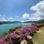 Rita Ferro Rodrigues Instagram - Dia 6 🤍 Como começar ? Antes de chegarmos ao lugar mais bonito que os meus olhos alguma vez vislumbraram fizemos uma viagem de duas horas de barco - porque este lugar situa-se no Parque Nacional Khao Sok , província de Surat Thani (Tailândia) e inclui os 165 km² do Lago Cheow Lan contido pela represa Ratchaprapha. Deve ser aqui que habitam todas as divindades da natureza - só pode ser aqui o seu refúgio - pois não é possível tanta beleza existir sem um qualquer toque divino. Aguardámos pelo barco com uma futebolada com crianças locais, fizemos a viagem com Sol, por entre várias tonalidades de água quente e doce que abraça escarpas magníficas e verdejantes, todas as cores da natureza em intensidade máxima, um espectáculo de poder do natural em bruto, uma parte do planeta muito preservada do toque humano. Chegámos ao @resort500rai com uma tempestade tropical a aproximar -se, bela e breve, e os pintainhos loucos de alegria, aos mergulhos à chuva , um descontrole de emoções ( tão bom !) perante o cenário de sonho. Totalmente sustentável , este resort constituído por pequenas , simples e confortáveis casinhas de madeira, munido de painéis solares, caiaques ( só saímos dos quartos nestes barcos que estão atracados à frente de cada habitação ) está totalmente integrado no parque natural. A partir das 22 h exige -se silêncio, o lema é “ disconnect to connect “ e por isso não há televisão e o serviço de wi - fi é muito limitado. A comida Thai é toda aqui confecionada - óptima - porque estamos no meio da selva, habitat de macacos, elefantes e outra bicharada fabulosa que vive em ambiente selvagem e que cumprimentaremos amanhã, numa das actividades que o resort proporciona. Não existe civilização por perto. Magia total ✨ Pintainhos e mãe vão dormir exaustos mas felizes. Amanhã é outro dia, cá estaremos para partilhar convosco. Muito amor aqui do Lago ❤️ #bestravel #bestravelviagens