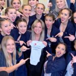 Sabrina Bryan Instagram - Annnnnnd here we are, back at USA Nationals again!! But first!!!!!! Here’s one of my FAVORITE memories with my team four years ago. Having all of my Glitterbugs and their families so excited when we gave them the news that we were pregnant with Monroe was one of the most special moments I’ve shared with my team! So blessed to be part of such an amazing program that feels more like a family! Can’t wait to create more memories for one LAST weekend with our 11 seniors! I love you Glitterbugs! LETS GOOOOOO!!! @ylhssong #whoareweYL