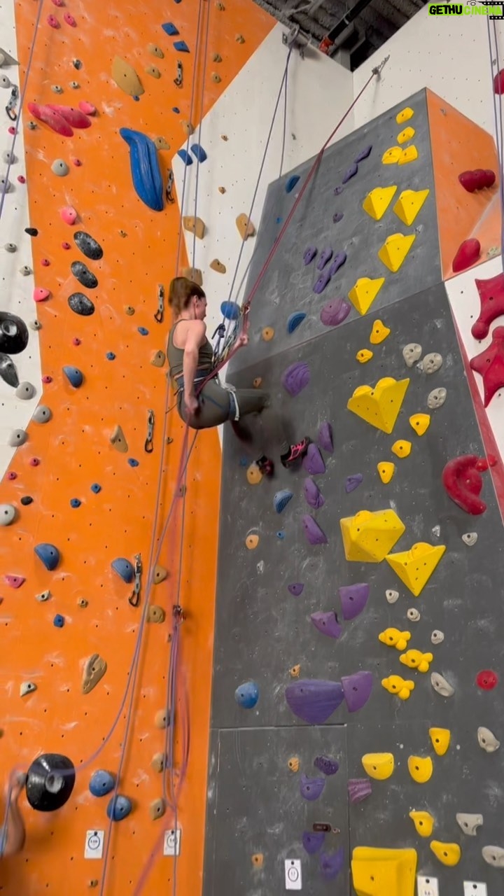 Sandra Mae Frank - 2.1K Likes - Doing stunts today for #TheSilentHour has me looking back to this moment; training for #NewAmsterdam, so here’s a throwback video of “cute-cute” rock climbing for #DamFam 😎💙
I love being active, and it’s good for the soul.
#RockClimbing #Repelling #Action
Sandra Mae, a white woman in a green yoga outfit with pink shoes, repelling on a rock climbing wall with colorful rocks.
