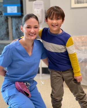 Sandra Mae Frank Instagram - Tune in tonight to watch this adorable deaf actor, #OliverReilly, shine on #NewAmsterdam! 

Also excited to share that the writer of tonight’s episode is deaf,  #GisselleLegere! 

#DamFam #DrWilder #DeafActors #DeafWriter 

[image description]
Sandra Mae, as Dr. Wilder, is wearing blue scrubs with a pink cap, is smiling, and sitting beside a young actor wearing tan pants & blue stripes with a yellow long-sleeve shirt. Both are smiling and looking at the camera.