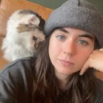 Sarah Desjardins Instagram - Kim is sitting in my lap as I write this. I wouldn’t be able to do it otherwise. 23 years is almost unheard of for a cat. She stuck by my side as long as she possibly could. She knew I needed her more than I did. Today I had to let the love of my life go. I will never forget every second I spent with her. Kim may have been a cat but she behaved like a human being. She understood all my emotions and gave me so much unconditional love and empathy. She spooned with me in the mornings, she curled up on my chest when she could sense that I was sad, she just wanted to be touching me at all times to be honest with you…even if she sat next to me and just placed her paw on my hand. Since I was a kid we were always in it together. She’s moved with me through every city and season of my life. I’m so deeply grateful to have gotten to share it with a little lady this special. My life has always contained a lot of heaviness and Kim has willingly carried that load with me. As of late it’s felt as though my nervous system is finally nearing a point where it’s ready to release some of that weight…no doubt in part to her. A new chapter lies ahead and in the most devastating way it almost makes sense that she wasn’t meant to come with me. (I’m crying now and Kim has migrated to rubbing against my face) While it will be impossible not to feel her absence I will also always carry the profound impact she had on my entire being, the way I love and how I walk through life. Goodbye Kim ♥️ You will be with me forever. watch the last slide till the end. I just found it and it kills me 🤍