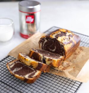 Silvia Colloca Instagram - I make this tea cake more than I make tea! It’s so so good. Look at those hypnotic swirls of cocoa and @illyinaustralia 
Espresso and Vanilla Swirl Loaf Cake

From my new show @silviasitalianmasterclass 
Ingredients

3 eggs
180 gr  caster sugar
200 gr  self-raising flour
65 gr  almond meal
60 ml (1/4 cup) extra virgin olive oil
1/2 cup (125ml) Buttermilk
1 teaspoon of vanilla extract
3 tablespoons of dark cocoa
50 ml of espresso (replace with same amount of warm milk or water if coffee is not your vibe)

Method

Preheat the oven to 180C. Grease a loaf tin. 
Whisk eggs and sugar until pale and creamy.
Add the oil, buttermilk and the vanilla.
Gently fold in the flour, well sifted. Mix until the batter is combined, then add almond meal and mix to combine.
Pour 1/2 of the mix into one bowl and the other half into another bowl along with the cocoa powder and espresso. Evenly dollop batter into the baking tin alternating between both mixtures to create a swirl pattern.  Add 3 tablespoons of dark cocoa and the espresso to the remaining cake batter and mix until smooth.
Dollop the cocoa mix on top of the vanilla mix and , using a fork or a chopstick, to swirl the two batters together. Bake for 35-40 minutes, or until a skewer comes out clean. Allow to cool before serving.
@channel10au @10playau