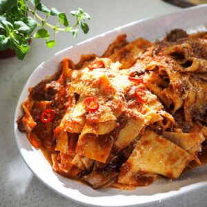 Silvia Colloca Instagram - Just a reminder that you can make any day a bit better with pasta.
This is my broken lasagne with lamb ragú 
Ingredients

60 ml (¼ cup) extra-virgin olive oil
3-4 garlic cloves, bashed
3-4 lamb forequarter chops (see Note)
200 ml red wine
2 400 ml cans chopped tomatoes
¼ red capsicum
sea salt and freshly ground black pepper, to taste
400 g lasagne sheets, broken into irregular pieces
grated pecorino, to serve
1. For the lamb ragú, heat the oil in a large, heavy-based saucepan. Add the garlic and cook for 2-3 minutes or until fragrant. Add the lamb chops and cook until browned all over. Add the red wine and simmer over high heat for 2 minutes to reduce slightly. Add the tinned tomatoes, capsicum and 800 ml water. Bring to a simmer, then reduce the heat to low, cover and cook, stirring occasionally for 3–4 hours or the until meat falls off the bone. Nonna would lift out the meat and reserve it for another meal. You can do that too or simply remove it from the pan to shred and get rid of any tiny bones and then add it back to the sauce. Remove and discard the capsicum, then season to taste.

2. Bring a saucepan of salted water to the boil. Drop in the broken lasagne pieces, stir and cook for 5-6 minutes or until al dente. Remove with a slotted spoon straight into the pan with the sauce, dragging along a little pasta cooking water, then toss well. Bring to the table and serve with freshly grated pecorino. 
❤️🇮🇹