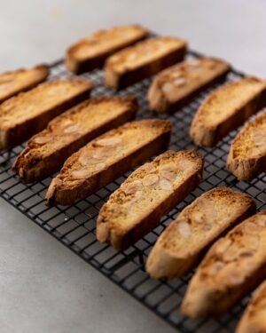 Silvia Colloca Instagram - The most loved Italian biscuits: biscotti!
Crunchy, nutty, sweet… perfect for dunking!
Made with beautiful @mulinocaputo flour and Colavita olive oil, distributed in Australia by the amazing Basile family, long time collaborator of mine @basile_imports 

Lemon and Almond Twice Baked Tuscan Biscotti
Ingredients

2 eggs
3 egg yolks
350 g caster sugar
1 teaspoon vanilla paste or extract
450 g self-raising flour, sifted (or plain flour mixed with 1 tablespoon of baking powder)
1 tbs baking powder 
1 tbs extra virgin olive oil
pinch of salt flakes
finely grated zest of 2 lemons
200 g blanched almonds
Preheat your oven to 190°C (170°C fan-forced) and line a large baking tray with baking paper.
Place the eggs, egg yolks, sugar and vanilla in a mixing bowl and beat until pale and creamy. Add the flour,baking powder  oil, salt and lemon zest and then the nuts. Shape the dough with floured hands to form two logs. Place the logs on the prepared tray, spaced well apart to allow for spreading, and bake for 25–30 minutes or until well risen and pale golden. 
Remove from the oven and cool at room temperature for 3–5 minutes, then cut them on an angle into 1–1.5 cm thick slices. Make sure you use a very sharp serrated knife to ensure neat slices. You will notice than the inside of the biscuits are still a little wet – this is fine. 
Arrange the slices on the lined tray and return to the oven for 5 minutes. Turn them over and toast for a further 15 minutes or until crisp and golden. Cool at room temperature, then serve with gelato, coffee or your favourite dessert wine. Any leftover tozzetti will keep in an airtight container for up to 2 weeks.

Watch @silviasitalianmasterclass on @channel10au and @10playau