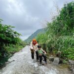 Tika Bravani Instagram - Pertama kali nih, Kalam nyobain hiking dan susur sungai. Ternyata nggak seburuk yang kukhawatirkan. Dia selow aja waktu kakinya kotor kejeblos lumpur. Paling dia ngereog dikit setelah kepleset di sungai. Wajarlah. "Ibuu aku capek.. ibuu aku laper.. ibuu aku ngantuk.." Anak rewel ya dinikmati aja, sambil nongkrong ngemil arem-arem di pinggir sungai. Kapan lagi begini? Meski begitu, anak baikku tetap jalan karena tujuannya..... kembali ke parkiran 😅 Pengalaman yang sangat beda, dan perlu diulang. Thank you @penjelajahcilik.id @hikingtherapyhill yang sangat ekstra banget penjagaannya. Bikin aku ngerasa aman di saat arus sungai tiba-tiba deras 😅
