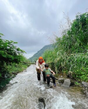 Tika Bravani Instagram - Pertama kali nih, Kalam nyobain hiking dan susur sungai. Ternyata nggak seburuk yang kukhawatirkan. Dia selow aja waktu kakinya kotor kejeblos lumpur. Paling dia ngereog dikit setelah kepleset di sungai. Wajarlah.
"Ibuu aku capek.. ibuu aku laper.. ibuu aku ngantuk.."
Anak rewel ya dinikmati aja, sambil nongkrong ngemil arem-arem di pinggir sungai. Kapan lagi begini?
Meski begitu, anak baikku tetap jalan karena tujuannya..... kembali ke parkiran 😅

Pengalaman yang sangat beda, dan perlu diulang. Thank you @penjelajahcilik.id @hikingtherapyhill yang sangat ekstra banget penjagaannya. Bikin aku ngerasa aman di saat arus sungai tiba-tiba deras 😅