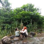 Tika Bravani Instagram - Pertama kali nih, Kalam nyobain hiking dan susur sungai. Ternyata nggak seburuk yang kukhawatirkan. Dia selow aja waktu kakinya kotor kejeblos lumpur. Paling dia ngereog dikit setelah kepleset di sungai. Wajarlah. "Ibuu aku capek.. ibuu aku laper.. ibuu aku ngantuk.." Anak rewel ya dinikmati aja, sambil nongkrong ngemil arem-arem di pinggir sungai. Kapan lagi begini? Meski begitu, anak baikku tetap jalan karena tujuannya..... kembali ke parkiran 😅 Pengalaman yang sangat beda, dan perlu diulang. Thank you @penjelajahcilik.id @hikingtherapyhill yang sangat ekstra banget penjagaannya. Bikin aku ngerasa aman di saat arus sungai tiba-tiba deras 😅
