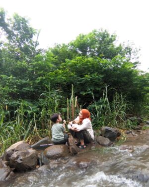 Tika Bravani Instagram - Pertama kali nih, Kalam nyobain hiking dan susur sungai. Ternyata nggak seburuk yang kukhawatirkan. Dia selow aja waktu kakinya kotor kejeblos lumpur. Paling dia ngereog dikit setelah kepleset di sungai. Wajarlah.
"Ibuu aku capek.. ibuu aku laper.. ibuu aku ngantuk.."
Anak rewel ya dinikmati aja, sambil nongkrong ngemil arem-arem di pinggir sungai. Kapan lagi begini?
Meski begitu, anak baikku tetap jalan karena tujuannya..... kembali ke parkiran 😅

Pengalaman yang sangat beda, dan perlu diulang. Thank you @penjelajahcilik.id @hikingtherapyhill yang sangat ekstra banget penjagaannya. Bikin aku ngerasa aman di saat arus sungai tiba-tiba deras 😅