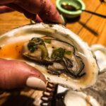Valentine Thomas Instagram - Food 😍 1- happy place 2- oysters on the grill 3- amberjack crudo, pomegranate, fennel 4- grilled oysters, Asian mignonnette, my dirty fingers 5- hasselback potatoes, anchovy cream 6- Cured gag grouper, smoked crème fraîche, capers 7- Turkish eggs 8- Butter clams 9- scallops carpaccio, cayenne, honeydew, ginger