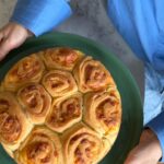 Veronika Arichteva Instagram - MILINKY - slaný bulharský buchty Až budete přežraný těch beranů a mazanců. Recept jsem obšlehla od švagrový @peknevypecenyblog , jak jinak : Ingredience (dortová forma s odnímatelným dnem o průměru 20 cm) 400 g hladké mouky (Babiččina volba na kynuté těsto) 100 ml vlažného mléka 5 lžic olivového oleje 100 ml vlažné vody 1 lžička mořské soli trocha mouky na zaprášení při kynutí mouka na posypání válu kousek másla na vymazání formy a mouka na její vysypání Na kvásek 1/2 kostky čerstvého droždí (21g) 2 lžíce vlažného mléka 1/2 lžičky cukru krupice Na potírání olivový olej na namazání těsta před zavinutím (přibližně 4 lžíce) 1 lžíce rozpuštěného másla na potírání jednotlivých částí při skládání do formy 1 lžíce rozpuštěného másla na potření po upečení Na náplň 200 g balkánského sýra 1 vejce Postup Nejprve si připravím kvásek. Do misky rozdrolím droždí, zasypu cukrem a přidám mléko, vše společně vidličkou promíchám a na teplém místě nechám pod utěrkou přibližně 10 minut. Do mísy od robota proseji mouku, přidám sůl a promíchám. Do mouky udělám důlek, do kterého dám hotový kvásek. Přidám vodu, mléko a olivový olej. Pomocí robota uhnětu hladké těsto, které lehce zapráším moukou a nechám ho pod utěrkou kynout na teplém místě přibližně hodinu (dokud nezdvojnásobí svůj objem). Troubu předehřeji na 170 °C, formu vymažu máslem. V míse rozdrolím sýr a smíchám ho s vajíčkem. Jakmile těsto nakyne, rozválím ho na moukou posypané ploše do tvaru tenkého obdélníku. Celý ho potřu olejem a podrobím sýrem, celý obdélník sroluji a nakrájím na 10 přibližně stejných kousků. Ty pak jednotlivě skládám do připravené formy a při skládání je jednotlivě po stranách mažu rozpuštěným máslem. Peču 30-35 minut a po vytažení z trouby potírám Milinki rozpuštěným máslem. A já dodávám dobrou chuť, je to fakt boží. Kuchyňská pracovní deska je @technistone_int ať se nemusíš ptát.