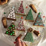 Veronika Danišová Instagram – Minule sme tu mali super odozvy na písané-statické recepty, tak skúsime ďaľší❤️ 🎄Kreatívne “cukroví” alebo nepečené STROMČEKY🎄…samozrejme ich môžete nakrájať aj ako malé stromčeky na jeden hryz🤤

Suroviny: 

210g arašídové maslo hladké
100g praclíky (Mixit preclíky – perníkové koření)
140g vločky (Mixit creamy oats)
70g lieskové orechy (Mixit pražené líškové ořechy)
170g ryžový alebo kukuričný sirup alebo med
80g mletý hnedý cukor

Postup:
Cukor a sirup/med dáme spolu zahriať do hrnca a miešame až do úplného spojenia a jemného zabublania, následne pridáme arašídové maslo a všetko premiešame až do jednotnej hmoty. Praclíky rozmixujeme nahrubo a lieskové orechy nakrájame nahrubo. Vločky, orechy, praclíky spojíme a zalejeme rozohriatou tekutinou. Plech o veľkosti 20x20cm vystelieme pečiacim papierom a hmotu roztlačíme po celom obsahu plechu. Doporučujem pracovať v gumených rukaviciach. Pekne to zahladíme a dáme na chvíľku do chladničky cca 20min. Pripravíme polevu. 

Poleva:

180g čokoláda (70%)
100g arašidové maslo 

Všetko spolu rozohriať vo vodnej lázni a naliať na schladnutý základ. Následne vložiť do mrazáku na cca 25-30 min a krájať na trojuhelníky. POZOR nenechávajte to mraziť/chladiť príliš dlho, čokoláda by mohla praskať alebo by sa vám to potom porcovalo ohromne ťažko. Stačí zachladiť tak, aby bol vrch na dotyk pevný. 

Kresba: 
Klasická cukrová poleva

1 bielok
200g preosiaty práškový cukor 
cca 1PL citrónovej šťavy 

Všetko vymiešať šlahacím nástavcom do požadovanej tuhšej konzistencie, vložiť do sáčku a zdobiť. 

Zdobenie: praclíky @mix.it , cukrové guličky, sušené maliny @mix.it a čokoľvek čo vás napadne❤️

#nebesky #stromceky #pecemenebesky #sladkaspolupraca