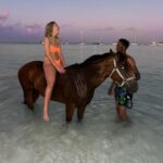 Victoria Spence Instagram - The most special morning 🥹🫶🏻 Every morning the race horses are taken to the beach at sunrise to roll in the sand, have a swim and get bathed. 🌅 We got talking to one of the guys and he asked if I wanted to get in, and next minute his hands were out ready to push me onto the horse😅 my heart was in my mouth at first, but it was the most precious experience! I’ll literally never forget it🥹 To top it off, he told me the horse was called Jerusalema after the song, which if you’ve been here a while, you’ll know my obsession with that song- one of my faves ever!🥲 I’ll remember this morning forever ❤️ @mikesingym can we get a horse?! #barbados#corememory