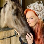 Wynonna Judd Instagram - My favorite horse won’t be @churchilldowns this weekend, but we’re still celebrating in style together! 🤍🐎 (I’m so excited that I’ve been wearing my Derby fascinator around the farm) 😆 Tune in to NBC THIS SATURDAY to see me perform the national anthem at #KentuckyDerby150!! Comment below who you’re cheering for…👇🏼 #WYinKY #KyDerby #KD150 #ChurchillDowns #NationalAnthem