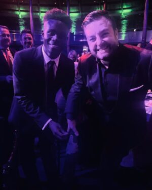 Alex Brooker Instagram - They say never meet your heroes (and tell them you’ve got a picture of them on your prosthetic leg). Still buzzing from meeting @bukayosaka87 on Monday! What a great guy and what a player 🔥 #arsenal #saka #legtattoos