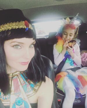 Alicia Minshew Instagram - Bring on Halloween! Donning my Cleopatra attire as we drive to my sister's party yesterday. It was a bright and gorgeous fall day. Miss Priss is very focused on her lipstick while her sneaky momma tries to catch her in action. Trying to perfect her rainbow unicorn. She sees me and is not having it! 😝Swipe to see how she turned out. So sweet. She did it all herself! Richie's costume is a whole other post! 🤣 #earlyhalloween #falltime #rainbowunicorn #mygirl #lipstick #misspriss #cleopatra #welovedressingup #happyfall