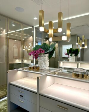Andrés Mercado Instagram - This  Master (piece) Closet, delivered by the best @ornaremiami in suede, and gold mirrored doors, beautiful leather island, and more exquisite details when you swipe. Adding to this elegant space we have the wonderful @leebroom with his signature pendant light. This Master closet was fully  covered on a light green-goldish wallpaper, to continue this green conversation with the super comfy silky rug, as usual, @lafloreria.atelier adding elegance to the space next to this neutral white art pieces, and beautiful accessories thanks to @jonathanadler