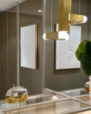 Andrés Mercado Instagram - This  Master (piece) Closet, delivered by the best @ornaremiami in suede, and gold mirrored doors, beautiful leather island, and more exquisite details when you swipe. Adding to this elegant space we have the wonderful @leebroom with his signature pendant light. This Master closet was fully  covered on a light green-goldish wallpaper, to continue this green conversation with the super comfy silky rug, as usual, @lafloreria.atelier adding elegance to the space next to this neutral white art pieces, and beautiful accessories thanks to @jonathanadler