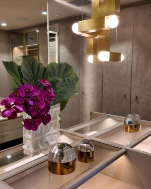 Andrés Mercado Instagram - This  Master (piece) Closet, delivered by the best @ornaremiami in suede, and gold mirrored doors, beautiful leather island, and more exquisite details when you swipe. Adding to this elegant space we have the wonderful @leebroom with his signature pendant light. This Master closet was fully  covered on a light green-goldish wallpaper, to continue this green conversation with the super comfy silky rug, as usual, @lafloreria.atelier adding elegance to the space next to this neutral white art pieces, and beautiful accessories thanks to @jonathanadler