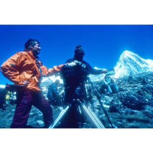 Araceli Segarra Instagram - Aquest cop, el Quim no m'haurà de recordar, com fa cada any, aquesta data que jo normalment oblido.
Avui fa no sé quants anys que vam pujar al cim de l'Everest aquella càmera gegantina, aquesta és la veritable fita. Una troup dirigida per un entusiasta, i contagiats per la seva passió i la seva ment incombustible i agosarada, la del David, recolzat per una productora familiar @macfreefilms i microscòpica comparada amb lo que és l'univers cinematogràfic Hollywoodient, però amb unes conviccions tant fermes capaces d'eclipsar al mateix Titànic (el nostre documental va competir i superar en les llistes dels Top 10 a aquesta pel·lícula)
Fa uns mesos va morir el David, i vaig apuntar a l'agenda que aquest any no em podia oblidar d'ell.
La sort, segons Sèneca, és quan la preparació és troba amb la oportunitat.
I jo afegiria que la preparació i l'atreviment, l'atreviment per provar sense por.
El David em va oferir la oportunitat i jo vaig aprofitar-la.
He endollat l'escaner que  el meu germà va reparar l'altre dia (gràcies Xavi, ets el puto amo 😻#sostenibilitat) i he rebuscat en un arxiu arraconat unes diapositives oblidades, imatges que no havia vist mai ningú, el director sent dirigit. Escenes de camp base, moments que em fan somriure i plorar. No, no tot és tant perfecte com els nostres records s'entesten en fer-nos creure, van ser dies difícils, complicats, emocionats, tristos i encoratjadors a parts iguals. Insuperables en resum, on vaig aprendre de la bondad i la miseria humana, de la fragilitat i la fortalesa, la valentia i la covardia, de l'egoisme, la ximpleria, del respecte i l'amor, en fí de lo que l'home està fet, tant al peu com al cim d'una muntanya.
Imatge 1:  Mirant per la finestra una setmana després del cim, els pensaments que em rondaven, me'ls reservo.(Aquesta foto me la va fer el David)
Imatge 2-4: El primer cop que tallava cabells, però el David no ho sabía 😂
Imatge 5: cámara, rodando, acción!
#Everest 
#everest1996 
#everestimax