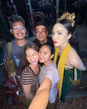 Aulia Sarah Instagram - i dedicated these pictures to all crew and all cast #BadarawuhiDiDesaPenari @kknmovie 💛 terima kasih untuk semuanya, sampai bertemu lagi di project selanjutnya 🤗💫

(slide 1)
pernah liat badarawuhi nangis ga? ga pernah kan?! nih aku kasih liat fotonya, pada saat kita wrapped filming #BadarawuhiDiDesaPenari 🥺🫶🏼

(slide 2)
terus bahagia akhirnya berkumpul lagi dalam rangka premiere film kita yang tayang perdana di IMAX dan menjadi film Indonesia pertama yang certified filmed for imax. bersyukur luar biasa.

(slide 3)
begitu selesai nonton langsung nyari mas @kimostamboel buat samperin dan mau bilang sesuatu “in a good way”. “overall aku suka hasilnya, makasih mas Kim”. lega, bahagia, masih degdegan, mix feeling seada-adanya. rasanya beruntung bisa di direct sama director yang hebat, yang bisa ngerangkul semua orang jadi team yg solid, baik hati, jenius, dan di sayang banyak orang ✨

(slide 4)
sebuah kehormatan juga buatku untuk bisa kerja sama lagi dan di percaya oleh bapak @manojpunjabimd dan kami jadi sering jumpa dalam urusan kerjasama di project ini, pun akhirnya merasa dekat karna team @mdpictures_official rasanya sudah seperti keluarga bagiku. terima kasih bapak atas kesempatannya & keyakinanmu.

(slide 5)
tidak lupa juga team photographer design poster yang luar biasa kerennya. team yg sama pula dengan film #KKNDiDesaPenari, kakak kakak cantikku @puja_k @indisaka masih kalian yang mengerjakannya, AKU HAPPY! karna aku tau hasil karya kalian selalu luar biasa menakjubkan 😻💘

(slide 6)
bu’de Elly choreographer tari tradisionalku selama proses preps, guru terbaikku. mengajarkan tarian bukan hanya sekedar hafalan melainkan sebuah rasa, punya nyawa & kekuatan yang sangat dalam ketika kita bisa memahami itu. aku sayang bu’de @ellylutan 🤗

(slide 7)
workshop hampir tiap hari dari reading lanjut latian nari sampe malem. semuanya sangat detail, “nginjek bumi pas nari” aja ada cara dan filosifinya, ada arti dan rasanya. dimana coba bisa dapet ajaran ini klo bukan dari bu’de Elly. latian harus super serius focus. capenya terbayarkan dengan ilmu yang kita dapat, bisa kita bawa pulang bahkan kita kenang dengan perasaan bahagia.