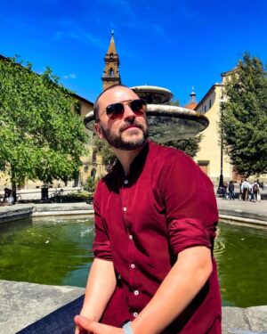 Benjamin Verrecchia Instagram - Se poser près d’une fontaine et réfléchir à la vie. Ça me rappelle une anecdote salée…
Rome 2009, j’étais mécano dans un garage à moto où le patron avait eu la mauvaise idée de me manquer de respect. Ça lui avait coûté un nez et une Ducati Diavel (Bicylindre en L à 90°). Bref. Je me retrouve un soir au Palazzo, une boite de nuit immense, un Titanic avec du son à mettre un coup de plafond au DJ. Dans ce foutoir je croise Mauro Casarelli, un mafieux, une petite frappe qui puait les coups fumeux. Cette sale petite tête de fouine avait pour mission ce soir là d’assassiner Gianni Accappatoio, un politicien propre comme un slip de forain. Mauro s’avance et se colle à l’oreille de Gianni, pour un traître plus le coup est sale plus il s’approche, c’est mathématique. Ce vieux sagouin s’apprête à sortir son canif, un couteau papillon rongé par la rouille et la rancune. Son objectif : planter la gorge de Gianni comme une motte de beurre et s’enfuir par une porte dérobée qu’il a prit le temps d’inspecter en faisant semblant de danser depuis une heure. Je l’attrape par le col et lui lance une droite dans l’estomac, un coup de marteau, j’ai visité son bide. Le temps qu’il crache au sol les 2 vodkas qui lui ont donné du courage, Gianni me sert la main et m’engage comme son garde du corps personnel.
Le lendemain je me cassais à Naples, une Ducati Diavel ça se chevauche.