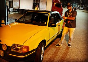 Buchecha Instagram - “ AMARELÃO “

O carro que fez o meu faixa virar chofer por um dia e levou o casal pra lua de mel , o ano era 1997 e eu havia casado,o meu motorista se empolgou e bebeu todas na festa rs (virou baile da PIPOS) obrigado Sr Alipio 😊🙏🏾.

aí ele se ofereceu pra nos levar,
relaxa tava tudo em casa,o piloto era da família e acabou que por essa razão o Claudinho foi com a gente e quer saber na moral ? Foi muito melhor assim!

(Ele virou o nosso DIRETOR) 

O irmão queria que eu ficasse do lado dele pra gente ir cantando e zoando enquanto dirigia na viagem até o local,mas eu disse: “ ah não po,vou ficar no carona com o meu amor “
Aí ele chamou na fita cassete dos mamonas assassinas que amávamos e fomos curtindo rumo a região dos lagos,eu tava doido que chegasse logo no local pra dizer o clássico: “enfim sós”  mas não é o que vocês estão pensando não hein rs 🤪 
Mentira ,era isso sim e também ,claro poxa uma mulher linda,vou fazer o quê? Era um direito e uma dádiva fascinante!
Eu só tinha 21 anos e ela 18 (justificando a nossa pressa rs) 

A Carreira tava ok ✅ 
A família tava ok ✅ 
A saúde mental e física tava ok ✅ 

A gente queria mais o que? 
A gente queria cantar e ser feliz , e também fazer as pessoas felizes com nossa música,nossa dança,nosso funk mélody e nossa alegria contagiante e sincera!

Esse carro ,um conversível da época,foi atração na favela,quando passava geral dizia: “é o Craudim”  e era ele mesmo,acenando de “vidro aberto”e largando o aço no som,ou mamonas ou racionais tava tocando,um dos dois,pra ouvir black music e pagode só quando eu estava com ele kkk 😂😂😂🫣

“Coé faixa , bota um fundo de quintal aê” aí ele ia meio contrariado e atendia o pedido,mas depois passou a amar pagode e Stevie Wonder tbm,por pura e espontânea pressão kkkk 😂😊🎵🏆🙌🏾🙏🏾

Sabe qual música ele amava também ?
Essa daqui ó .

“Descobri , que você é minha diretriz
É só contigo que eu posso ser feliz 🎵”

Ele me disse : “essa eu queria ter feito” 

Minha resposta foi: “é nossa meu faixa” 

NOSSO SONHO nos cinemas 🙏🏾