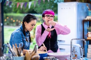 Cal Wilson Instagram - It’s @bakeoffau night again! Its International Week on @foxtel, 8.30 tonight. 

Please enjoy a selection of lovely, increasingly confusing photos 
#BakeOff #BakeOffAu #GABO 

(Images: 1. Four beautifully dressed people, @darrenpurchese, @rachelkhooks, Cal, and @natalie.tran stand together in the Bake Off Shed. Rachel is mid rousing speech, the other three look delightedly on. 

2. Natalie and Cal lurking charmingly at a baker’s bench. Natalie is helpfully stirring something, Cal is loading her mouth up with something delicious. I say mouth, it’s big enough to be a fireplace. 

3. Natalie is flexing her excellent biceps, while looking intensely offscreen at a baker. Cal is talking. It’s a common issue. 

4. Natalie and Cal stand smiling together, Natalie looks happy and reasonable, Cal is leaning back with her arms outstretched as if she’s trying to summon something. Possibly more cake. 

5. Cal and Natalie stand together smiling in a different part of the shed. They are looking offscreen. Cal is calmly cradling a pear in her hands like a proud bridesmaid holding a bouquet)