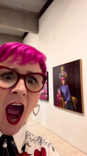 Cal Wilson Instagram - This amazing portrait by the brilliant @andreahuelinartist just won the @archibaldprize Packing Room Prize! 
I’m completely and utterly chuffed. 

(Video: Cal filming a little video, panning around a crowded gallery, suddenly catching sight of her brightly coloured self immortalised in a painting. AN ACTUAL PAINTING. Its pretty low key, just her dressed up in her finest wearing a glue gun headdress and an expression like a cat that’s about to swat a vase off a shelf)