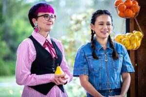 Cal Wilson Instagram - It’s @bakeoffau night again! Its International Week on @foxtel, 8.30 tonight. 

Please enjoy a selection of lovely, increasingly confusing photos 
#BakeOff #BakeOffAu #GABO 

(Images: 1. Four beautifully dressed people, @darrenpurchese, @rachelkhooks, Cal, and @natalie.tran stand together in the Bake Off Shed. Rachel is mid rousing speech, the other three look delightedly on. 

2. Natalie and Cal lurking charmingly at a baker’s bench. Natalie is helpfully stirring something, Cal is loading her mouth up with something delicious. I say mouth, it’s big enough to be a fireplace. 

3. Natalie is flexing her excellent biceps, while looking intensely offscreen at a baker. Cal is talking. It’s a common issue. 

4. Natalie and Cal stand smiling together, Natalie looks happy and reasonable, Cal is leaning back with her arms outstretched as if she’s trying to summon something. Possibly more cake. 

5. Cal and Natalie stand together smiling in a different part of the shed. They are looking offscreen. Cal is calmly cradling a pear in her hands like a proud bridesmaid holding a bouquet)