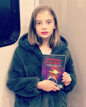 Carina Battrick Instagram - Guess what I was reading on my last day of filming @chuckyisreal season 3? Sorry Chucky but maybe you should write a book? I am sure it will be a top seller in no time 🙌
.
Channeling my inner Abby 😊
.
.
#fnaf #fivenightsatfreddys #chucky #caroline #chuckytvseries #abby #fivenightsmovie