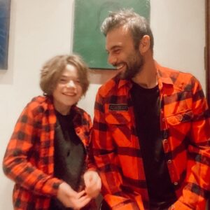 Cavit Çetin Güner Instagram - Bugün babamı çok özledim. Ansızın geldi özlem. İki gündür oğluma uzun uzun bakıyorum. Uyurken izliyorum onu. Nefes alışını, ağzı, dudakları ne güzel. Burnu hele. Kirpikleri… kılları çıktı baya. Bacakları kolları kıllı oldu. Saçları ne güzel. Mutlu olması için daha fazla ne yapabilirim acaba? Diye düşündüm. Sonra bir şey izledim. Bir baba bir çocuk ve bir dede vardı. Babam da oğlumu görseydi keşke diye geçirdim içimden. Sonra “ hiç keşke dediğim bir şey yok” dediğimi hatırladım geçenlerde. Yalan söylemişim. Sonra “Ali doğduktan sonra hiç yalan söylemedim” deyişlerim geldi aklıma. Söylemişim. @alidemirguner  bilgisayardan arkadaşıyla oyun oynuyordu. Onu izliyordum arkasından. Çok eğleniyordu, gülüyordu durmadan. Eskiden bizde çok gülerdik ama sanki son zamanlarda daha çok kuralları hatırlatan bir adama dönüştüm daha az güldüğümüzü fark ettim. Babama benzemeye başladığımı. Babam çocukları çok severdi ama bize pek sevgisini gösteremezdi. Bilirdik ama duymaz görmezdik. Şimdi yaşasaydı ve Ali’nin gülümsemesini görse, o da gülse beraber gülsek ne güzel olurdu diye düşünürken gözyaşlarımı tutamamışım. Ali iyi misin babiş dedi. İyiyim derken sesim öyle bir titredi ki o kısacık kelimeyi bile söyleyemedim. Sarıldık ve birbirimizi ne kadar çok sevdiğimizi söyledik, duyduk, gördük, hissettik. İyi ki babam babamdı, iyi ki oğlum oğlum. Ve iyi ki ben benim.