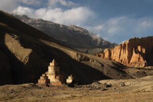 Cory Richards Instagram - Words by Ben Ayers @jetbutterflies // In the wide desert of Upper Mustang, the road planes along canyon walls and dry mountainsides dotted with hundreds of unspeakably ancient human-made caves. The light plays a slow game of chase with the shadows cast by the highest mountains on the planet, now behind us. We sweep the corners wide, drawn to cliff-edges teetering above the braided Kali Gandaki River below. We don’t know where to look – the road, the layers of tortured mountains, or the sand-castle parapets of rock and mud towering above us.
 
Instead, we watch the oncoming frame-bent jeeps as they roaring around the blind corners on bald tires. In Tsarang, the drivers share a rough kindness with us. We play snooker, a game we don’t know. Cory tries and fails to find a tutorial on YouTube. Nursing warm cans of beer, we realize the drivers don’t know how to play either.
 
The evening passes in one long, impossible game of scratches and flubs until the young man running the hall flicks the light switch and kicks us out into the cold, thin air of a star-streaked night.  @vacheronconstantin