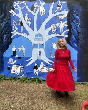 Cressida Cowell Instagram - So proud, went to visit the summer exhibition of Kindred Studios, the arts community in Shepherd’s Bush Market where my daughter Maisie has a studio…

Maisie here in front of the stunning mural she designed and was painted by another artist, John, from the studios. 

Kindred is such an amazing place, so much creativity, artists of every kind all working together: painters, photographers, musicians, and the title of the summer exhibition ‘a single tree doesn’t make a forest’ was all about the interconnected ness of nature and kindred spirits.

Here the poster Maisie designed for the studio and more of her beautiful work, and the work of others (the last pieces at the end created by fellow artists at the studio…)

Love the four roots of the tree on the poster: art, nature, generosity, kinship

Maisie’s Insta is @maisiecowell if you want to see more of her gorgeous work 

Such a lovely place
#artistcommunities
@kindredstudiosartists 
#❤️🌳❤️🎨